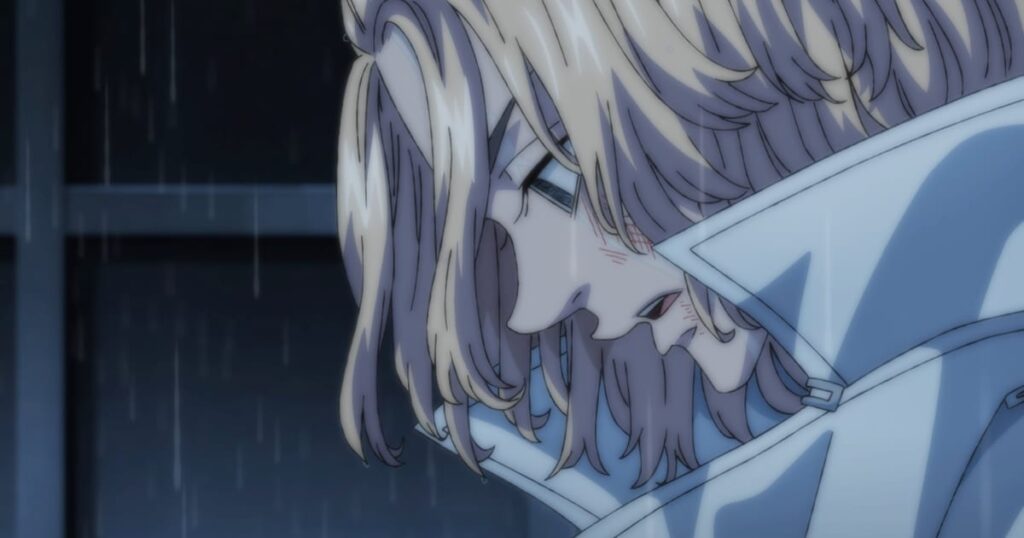 Mikey, con la gabardina blanca del Mikey adulto, de perfil y con la cabeza baja bajo la lluvia, en un fotograma del tráiler de la temporada 4 de Tokyo Revengers